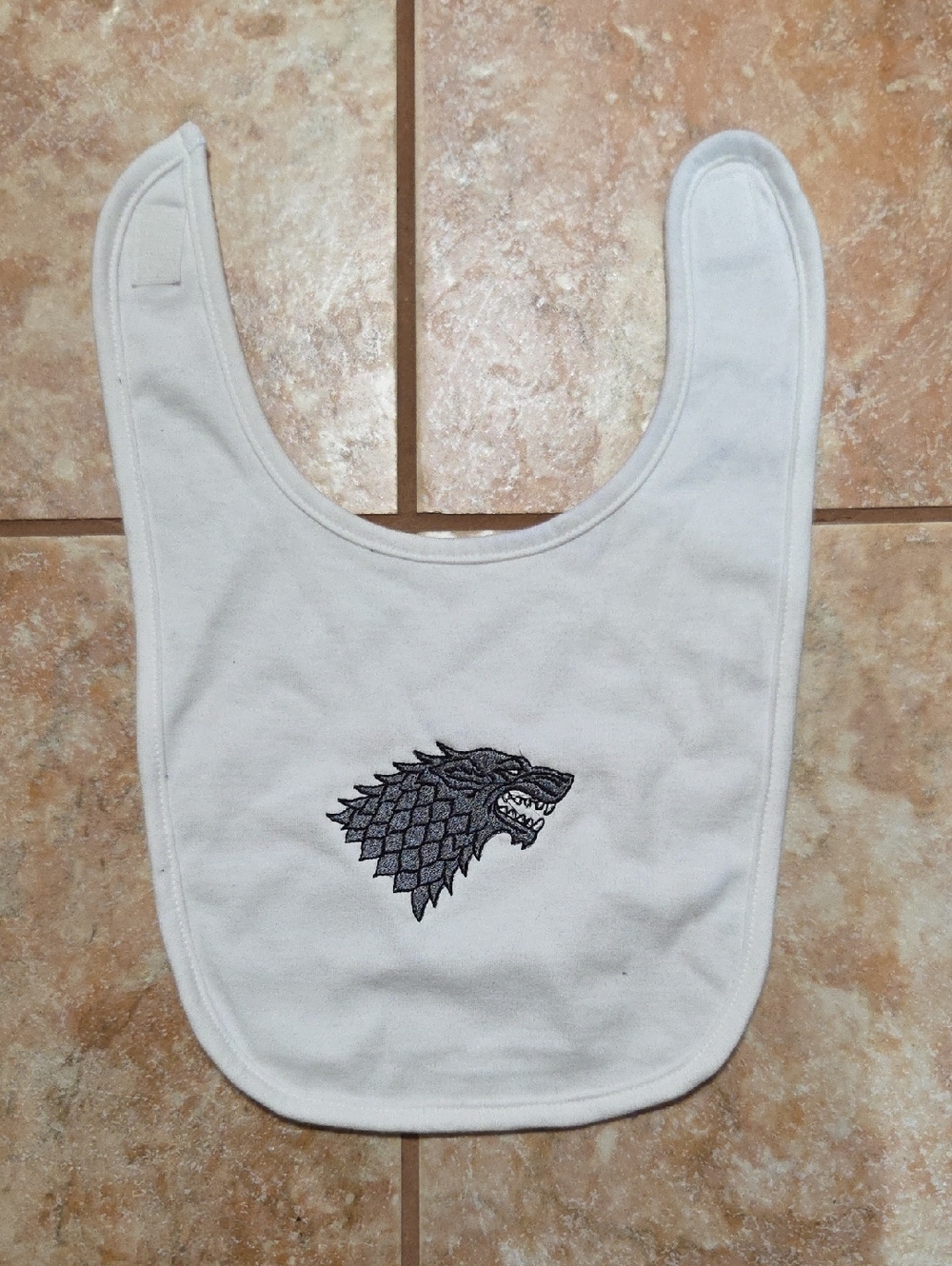 Embroidered White Baby Bib with Grey Wolf House Stark Crest